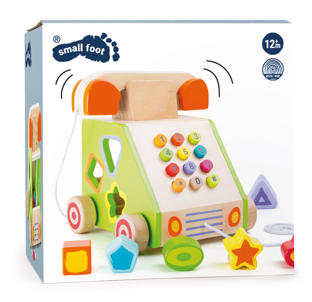 the package showing a wooden push button phone on wheels with shaped holes that correspond to colorful shaped blocks