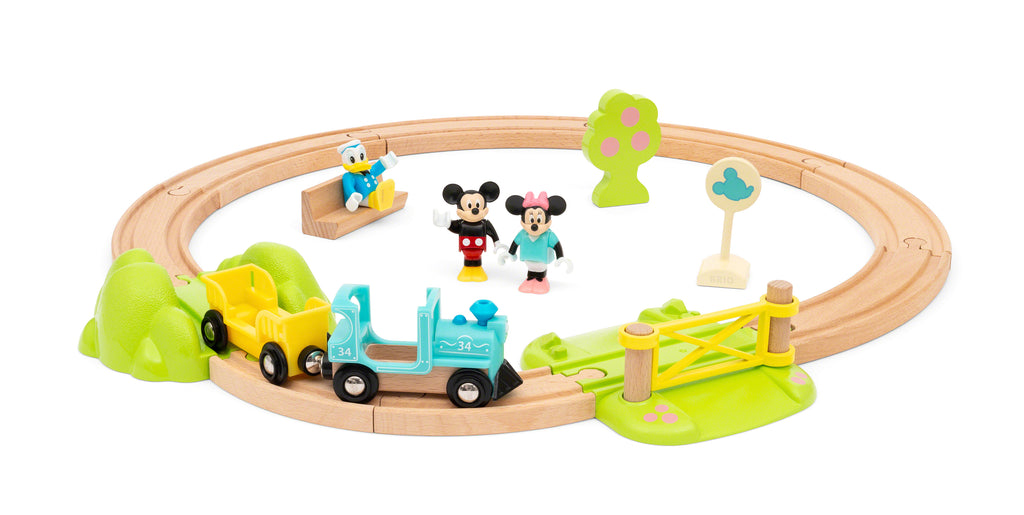 the track and train is set up with the figures and a wooden pench, tree, and sign