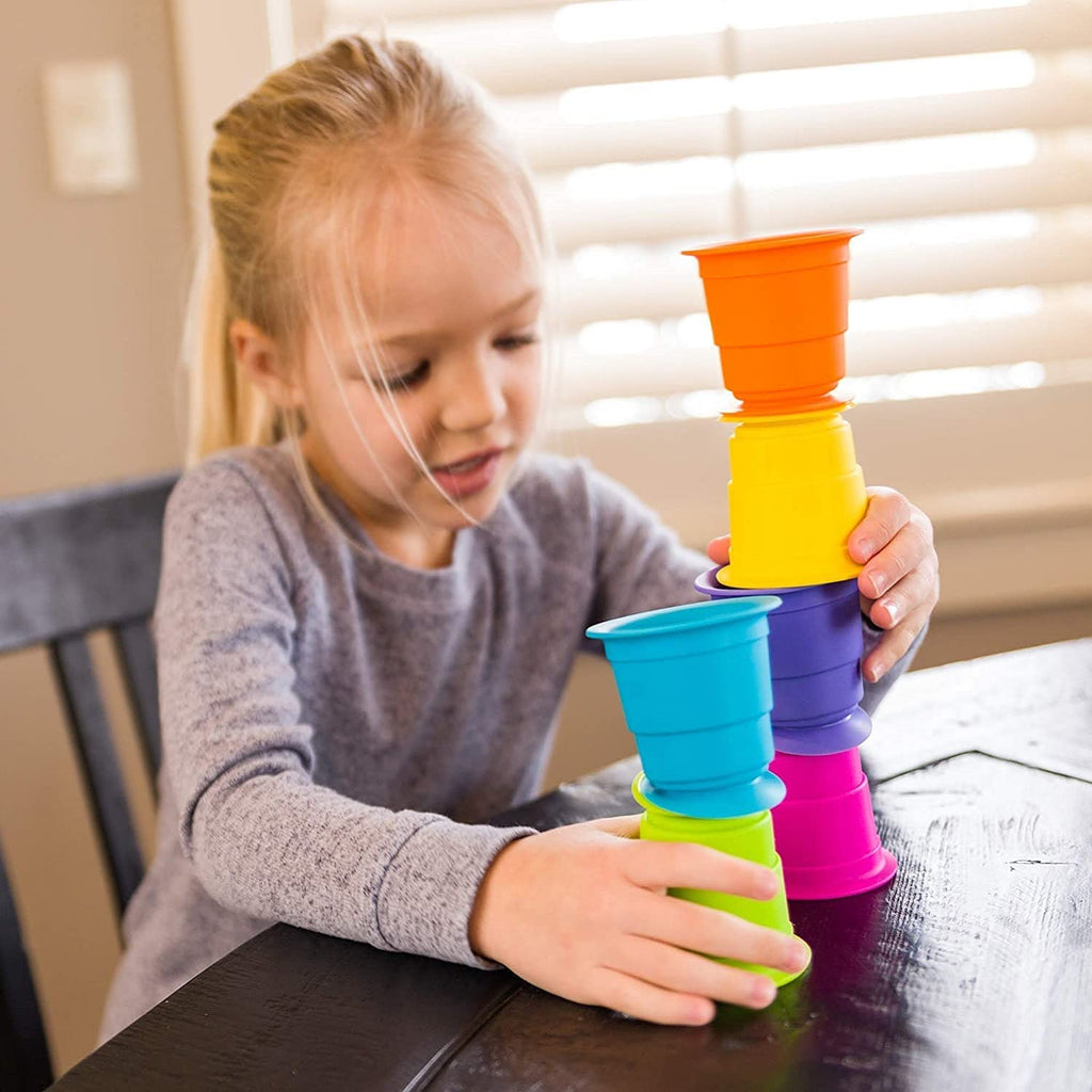a child stacking multicolored cups