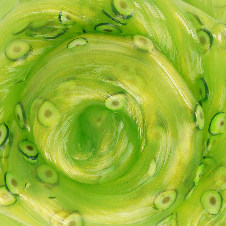 a close up of the swirling green putty with little sliced avocado pieces