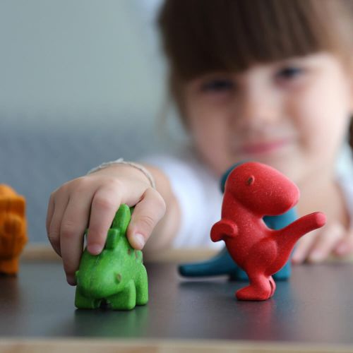 photo of child playing with green wooden dinosaur