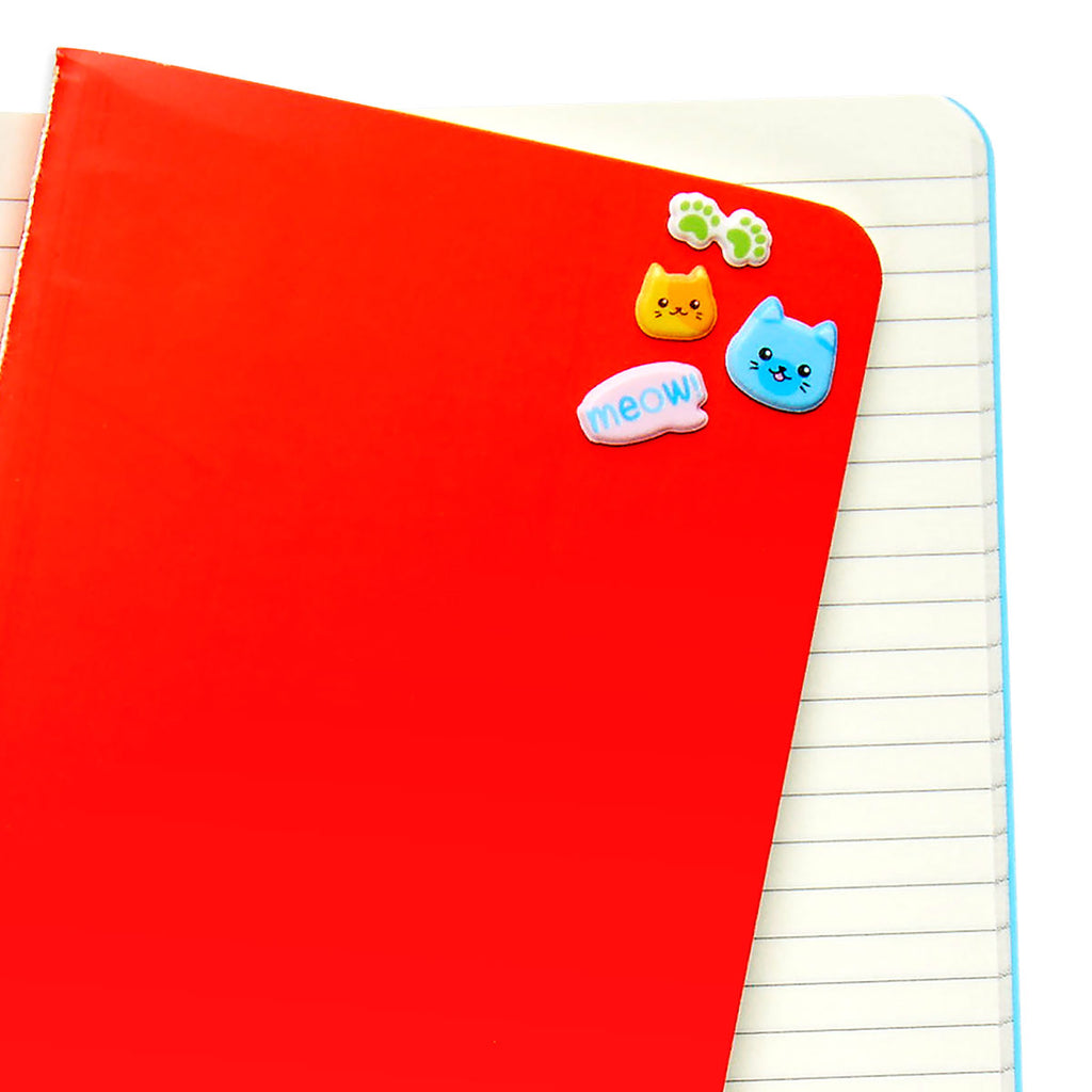 a variety of puffy cat stickers on a red folder