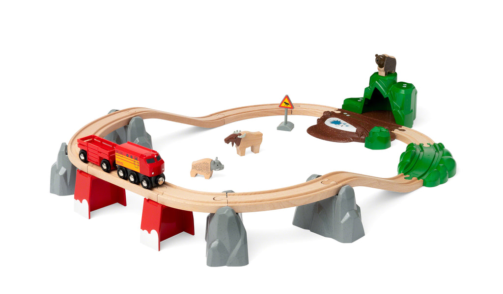 the full set showing track set up in a loop, forest animals, a cave, and sign