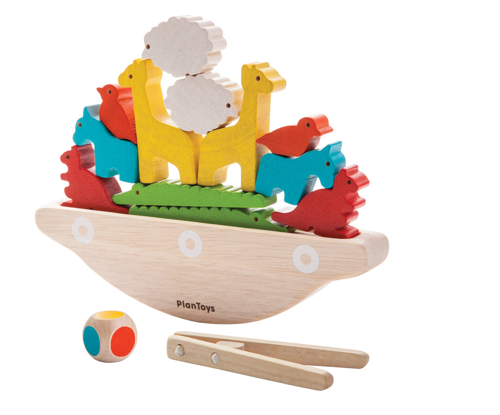the balancing boat with wooden animals stacked on it with a colored die and tongs nearby
