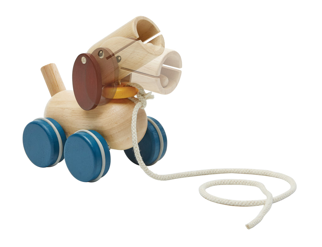 the wooden puppy on wheels with a cord on its collar. its head nods as its pulled