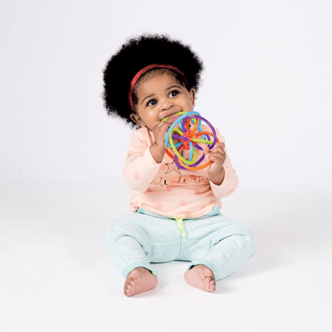 photo of baby playing with multicolored interwoven clutching rings