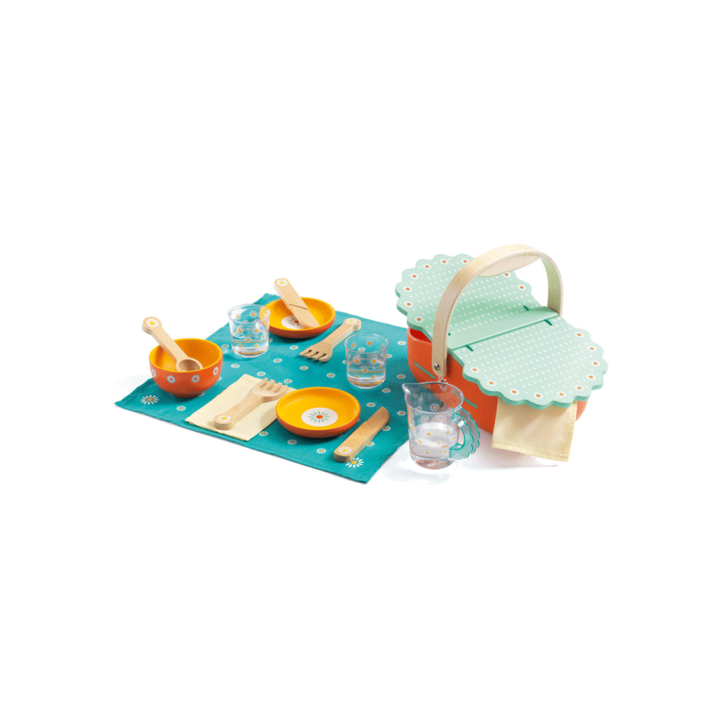 A toy picnic set featuring a basket, utensils, bowls, napkins, and a small blanket